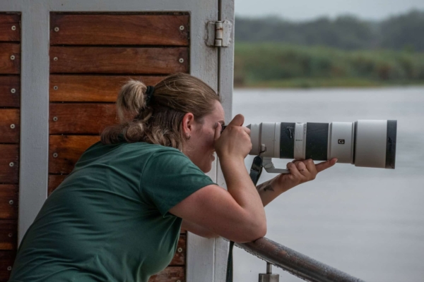 An intern taking a photograph with her large lens.