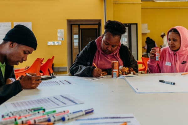 Men and women writing on papers during workshop