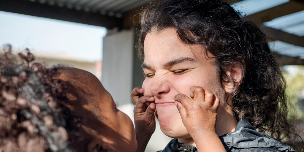 women having her face pinched by a child