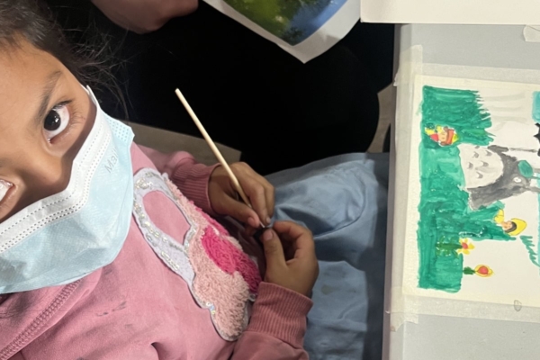 little girl with facemask and her artwork