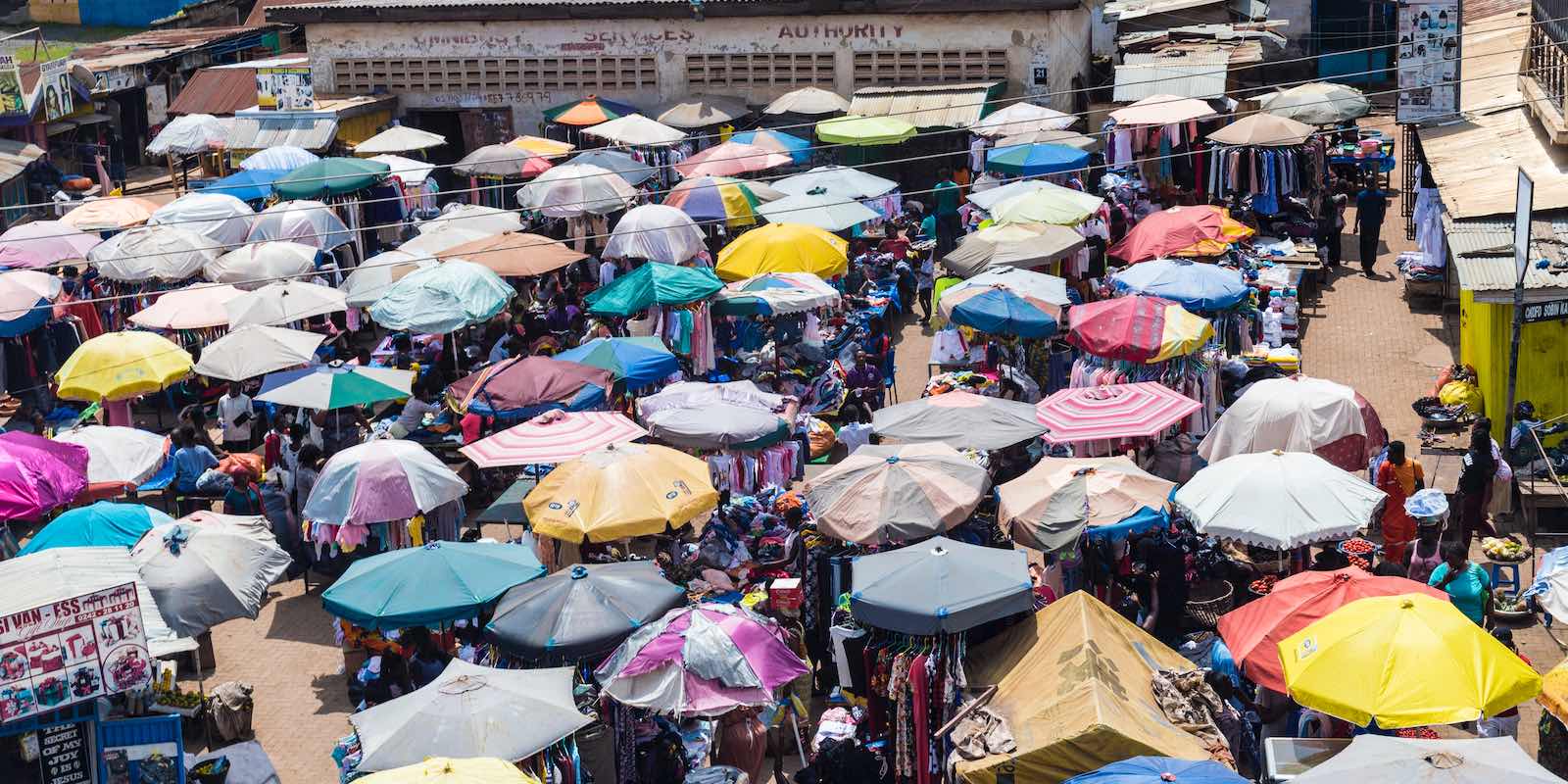 a crowd of people standing around with umbrellas in Ghana