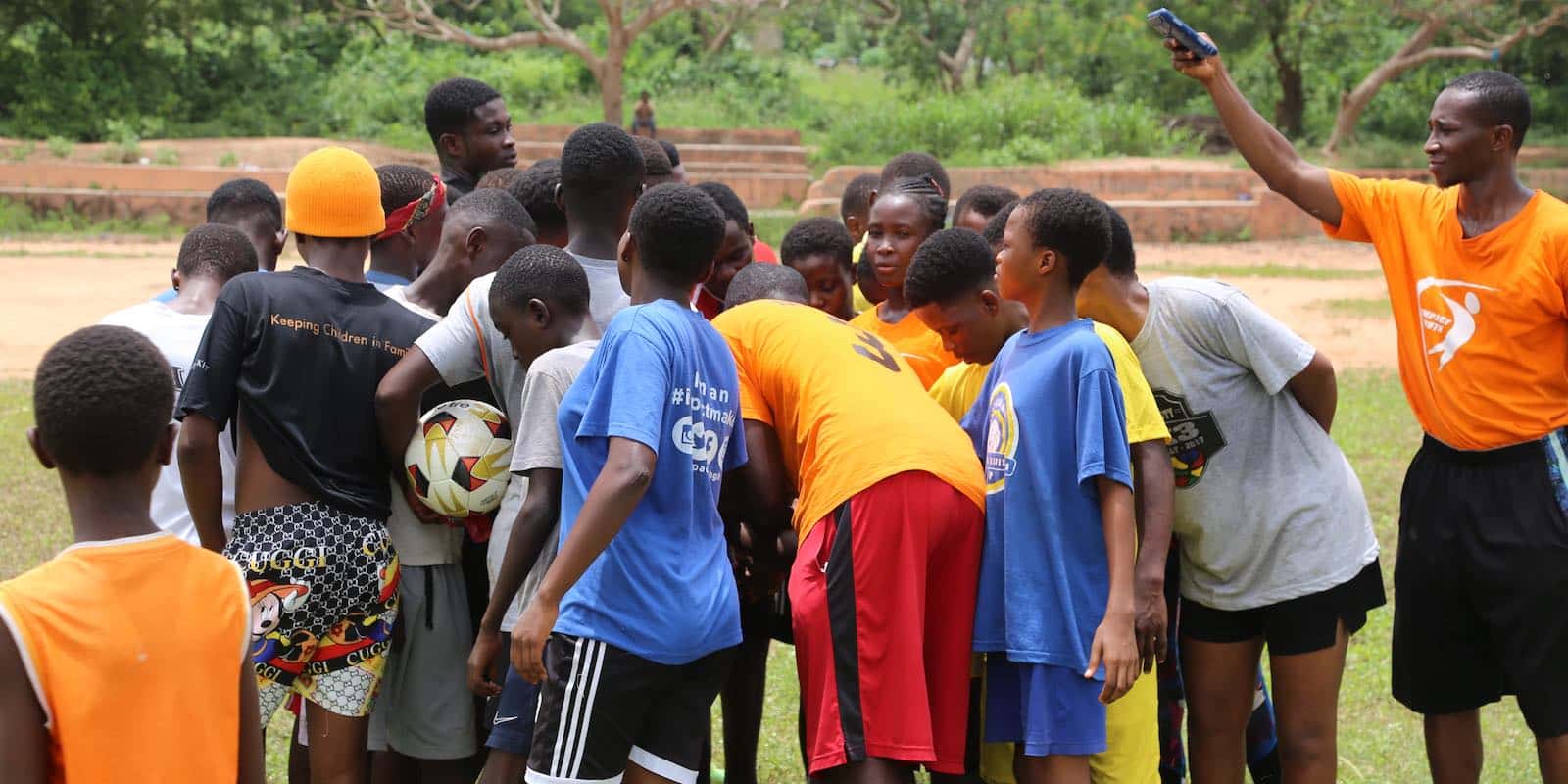 a soccer team standing next to each other in a field in Ghana