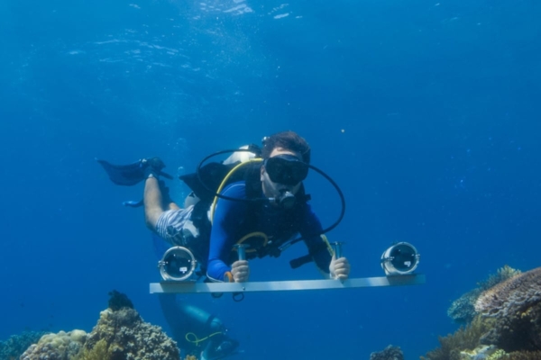 a man in a diving suit is on a metal beam