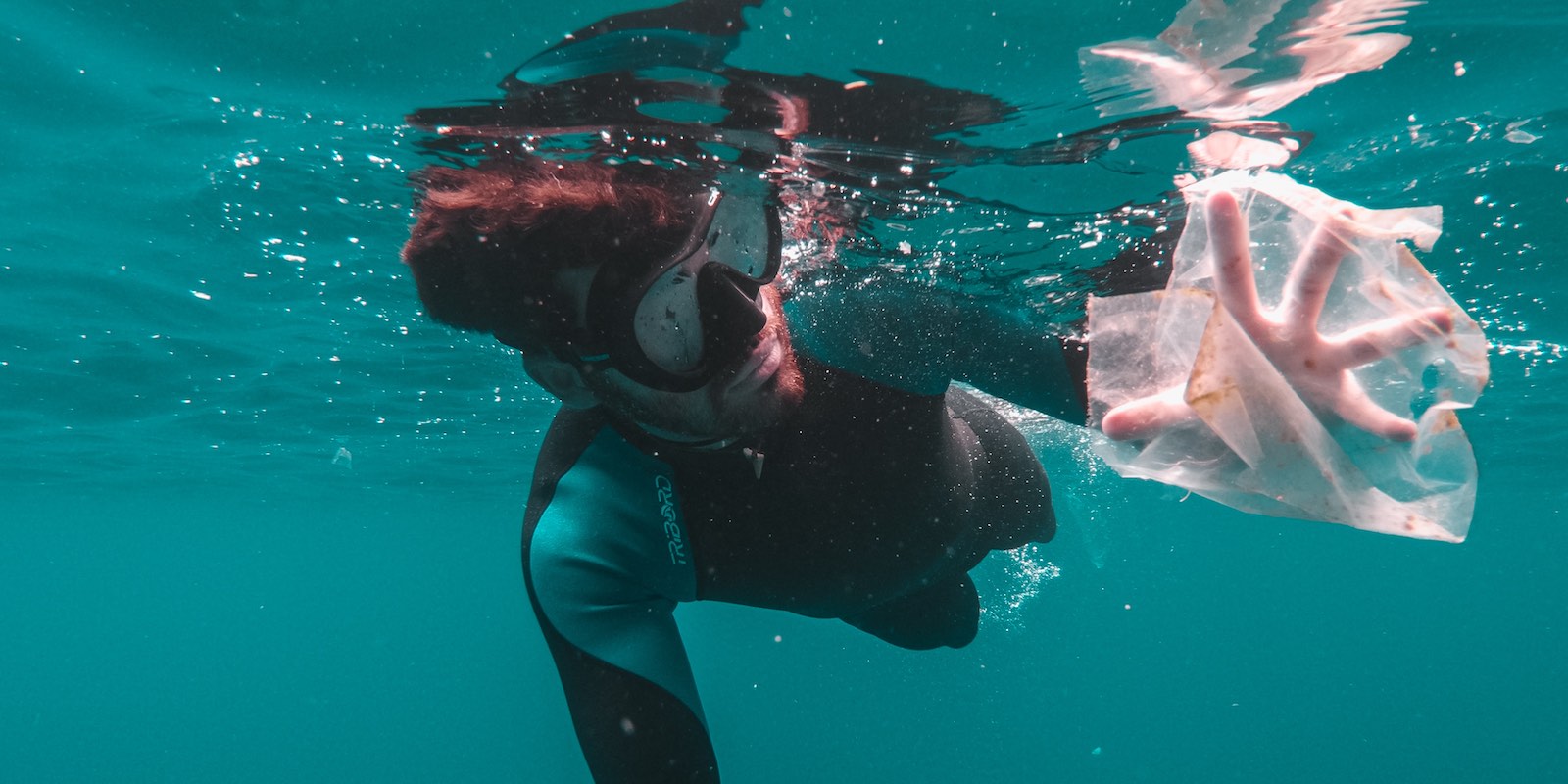 a diver collecting plastic trash underwater