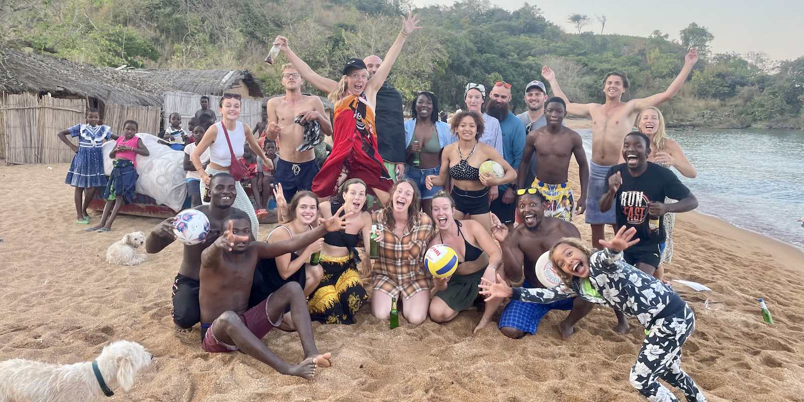 locals and interns happy together in a beach in Malawi