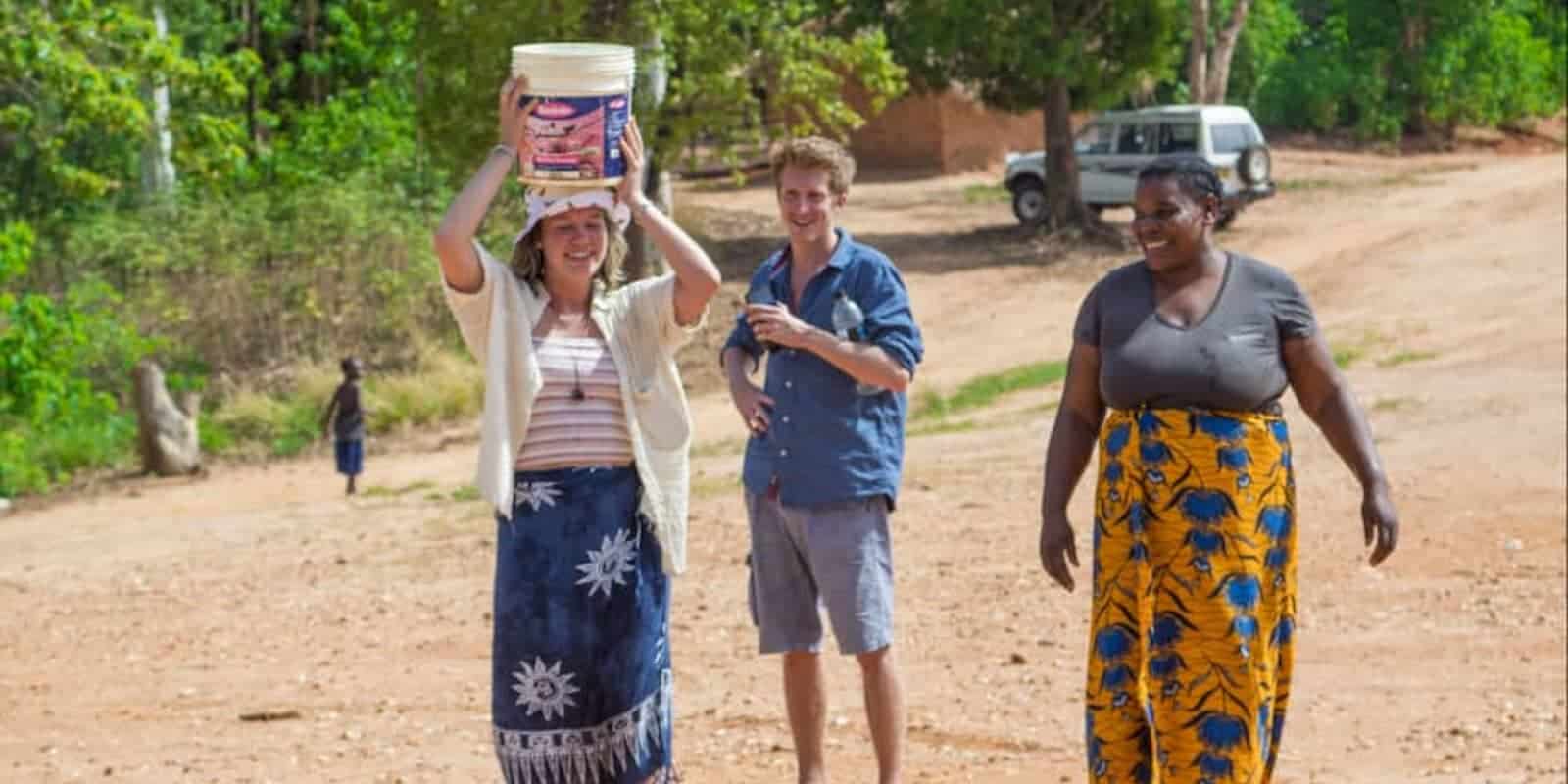 interns holding a diy bucket with a local in Malawi
