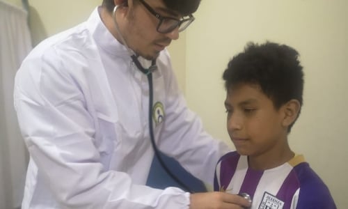 doctor checking boy's heartbeat