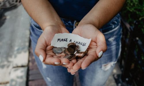 a woman holding a stack of coins and a piece of paper that says "make a change"