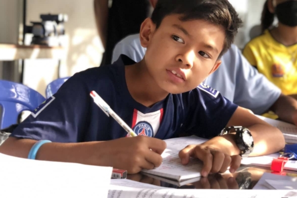 Boy in class room writing