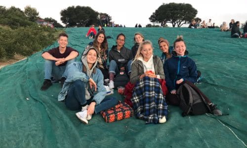 a group of people sitting on top of a green tarp