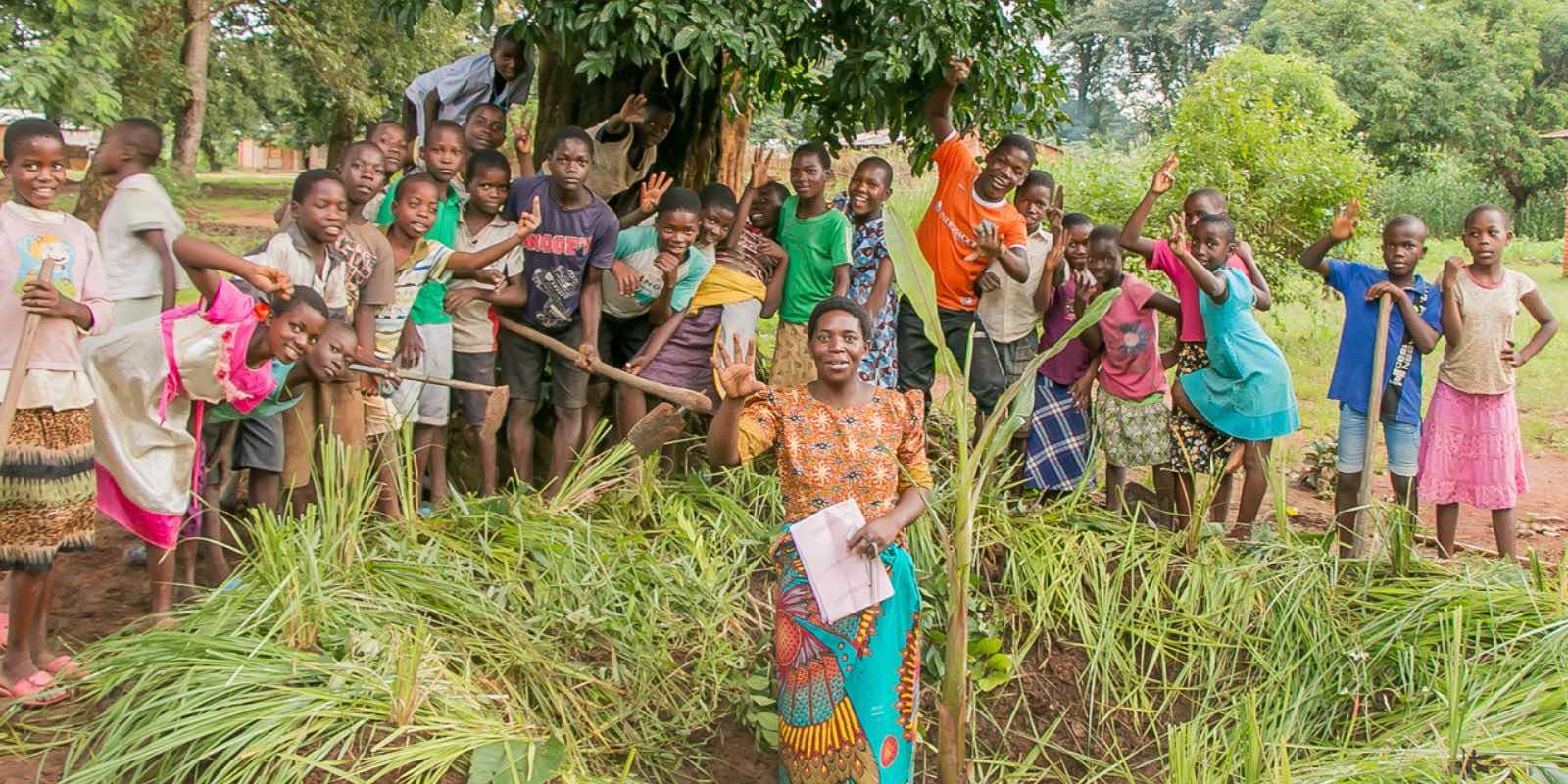 a local community in Africa having a group photo in front of a tree