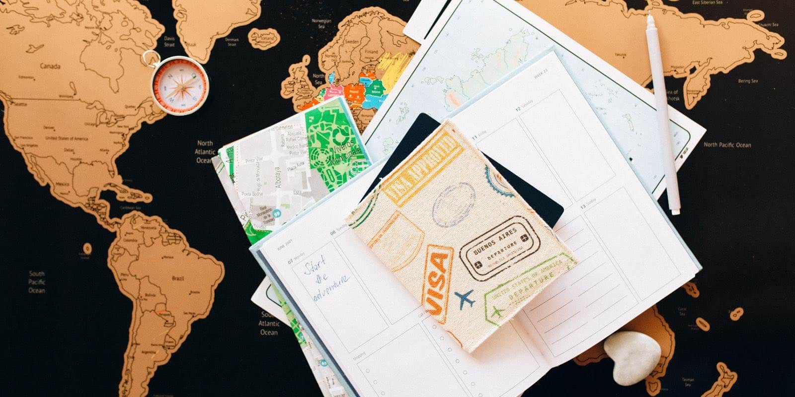 a visa and a planner on top of a world map
