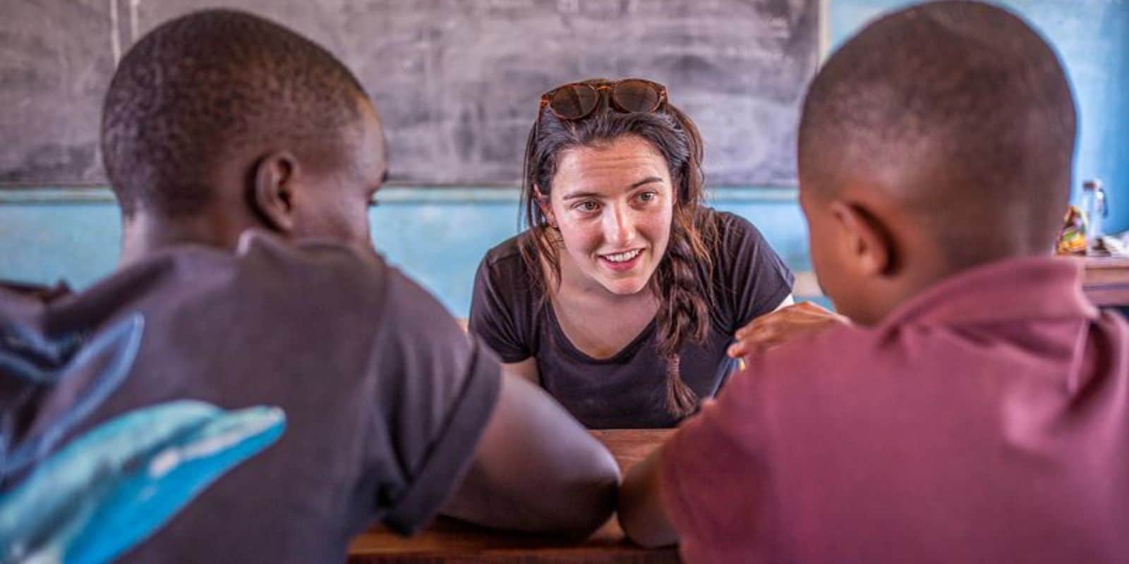 a woman intern teaching two local students