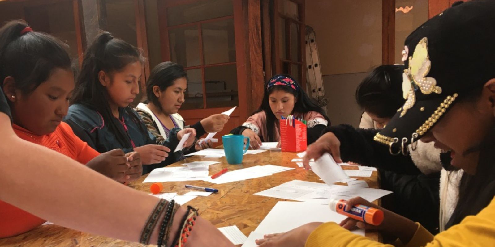 A group of girls working on papers at a table