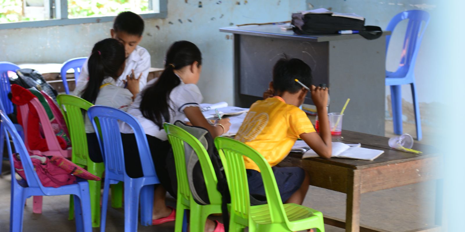 local kids writing in a classroom in Cambodia