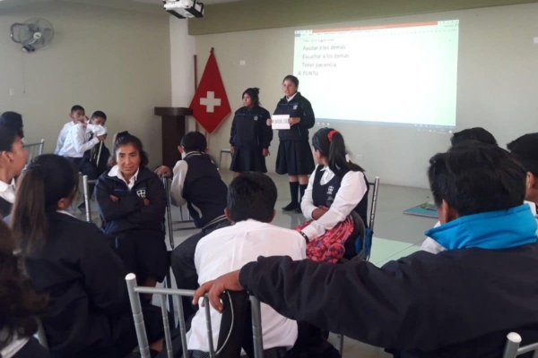 A group of people sitting in chairs and watching a presentation.