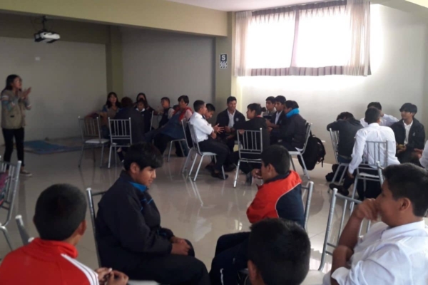 A group of people sitting in chairs in a room.