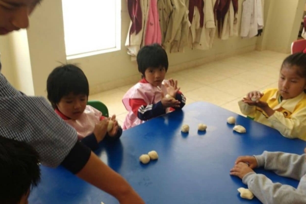 children rolling doughs while sitting down