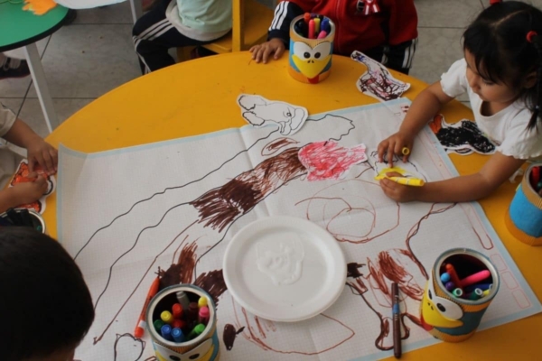 a group of children in a round table drawing