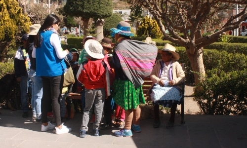 group of peruvians talking near a bench