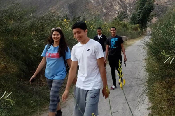 A group of people walking down a path in the mountains