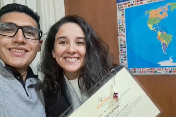 A man and woman posing with a certificate in front of a map