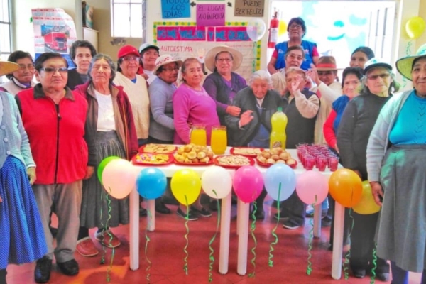 A group of people standing around a table with balloons