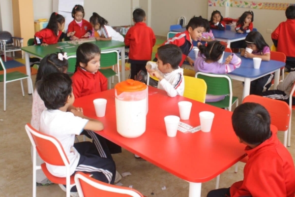 A group of children sitting at tables in a classroom