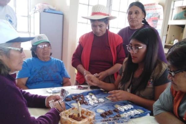 A group of people sitting around a table eating cookies