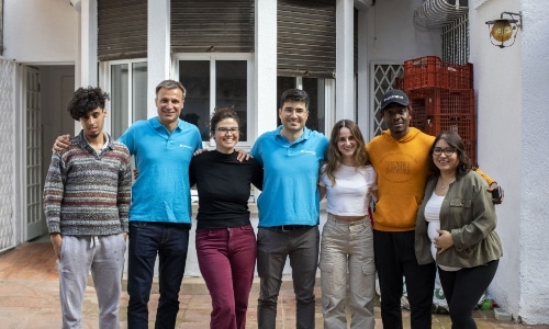 migrants posing for a photo in front of a shelter