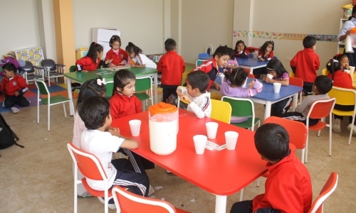 A group of children sitting at tables in a classroom