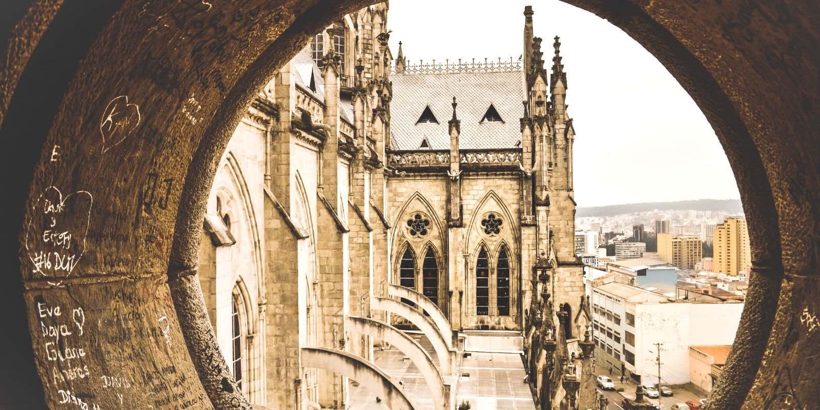 view of a cathedral through a round window in Quito, Pichincha, Ecuador