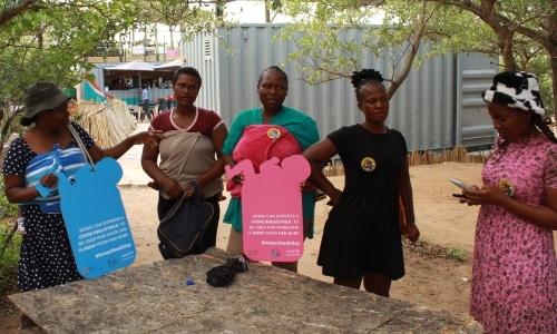 Women with information signs about breastfeeding