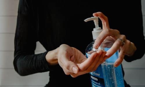 a woman applying hand sanitizer
