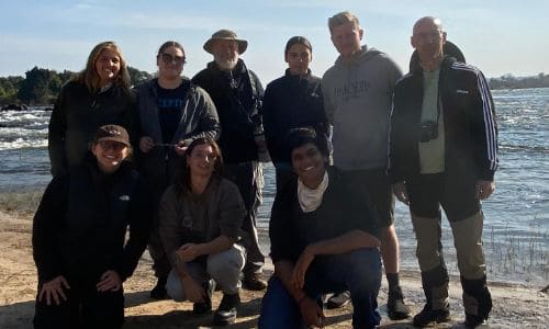 group of interns posing for a photo on the beach