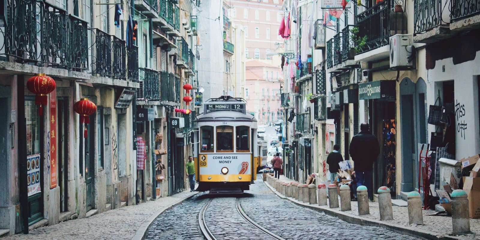 a train between buildings in Rossio, Lisbon, Portugal
