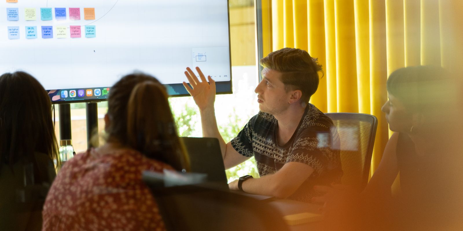 colleagues having a meeting and looking at a TV monitor