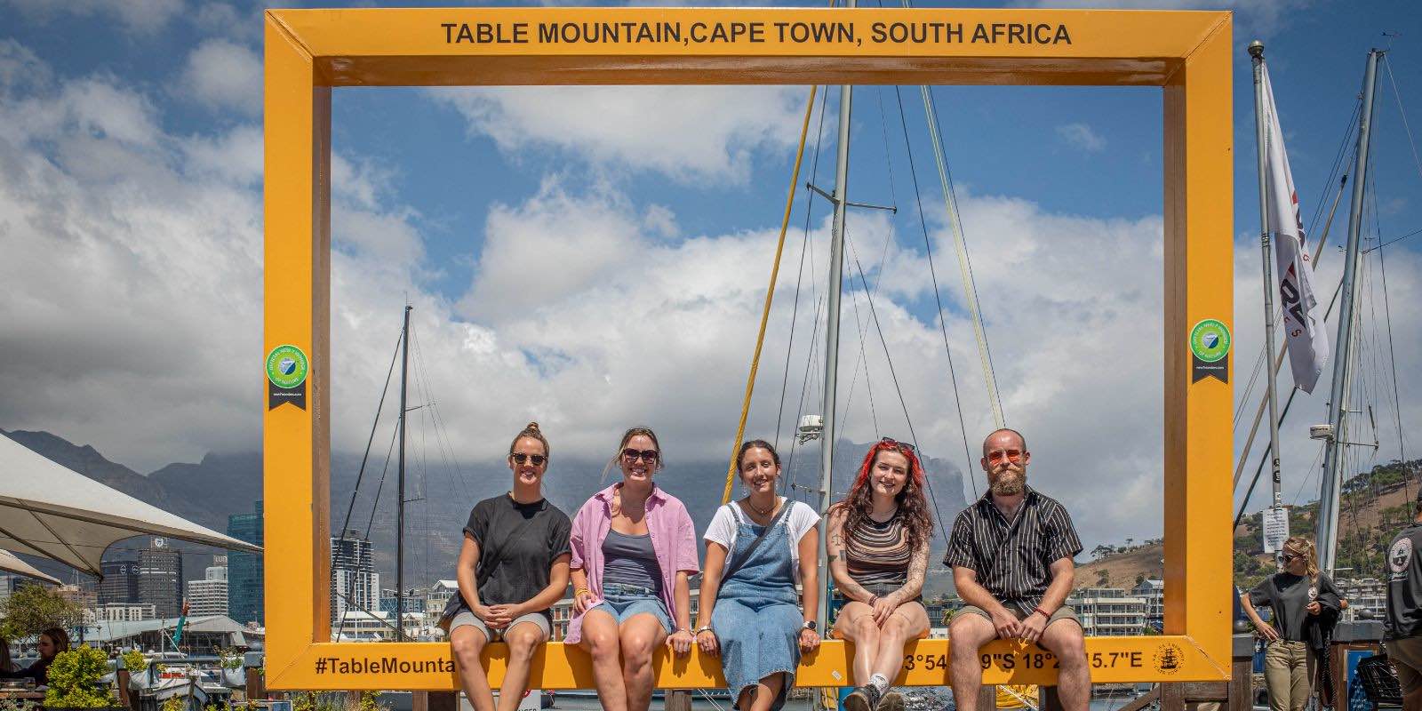 interns sitting on a big rectangle in Table Mountain, Cape Town