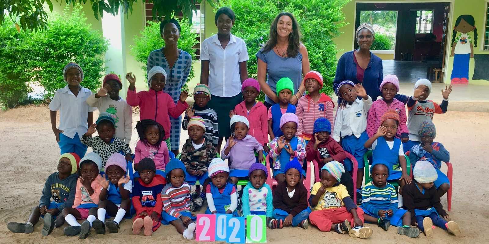 group photo of an intern with children and adults in South Africa