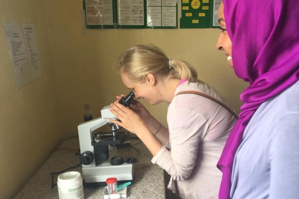 medical intern looking through a microscope