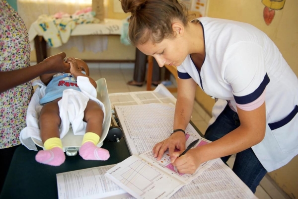 medical intern updating records of child patient