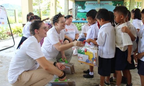 volunteers giving school supplies to students in Tacloban City