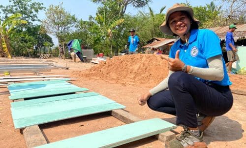 Volunteers working on a construction project in a rural village setting
