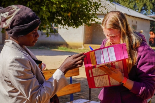 public health intern in zambia providing information to a patient
