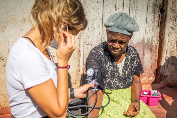 public health intern in zambia taking blood pressure
