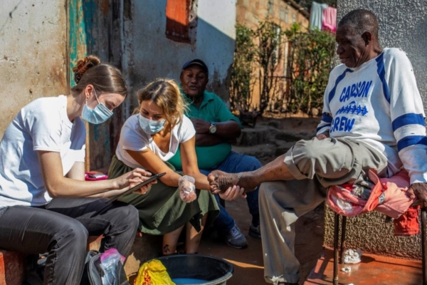 public health interns in zambia treating a patient's foot