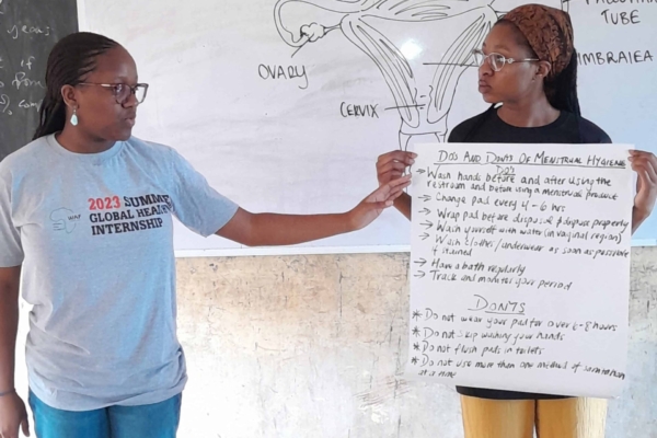 Two interns presenting about women's reproductive health.