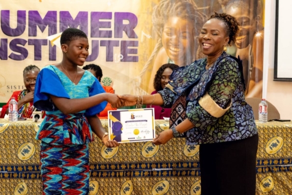 A proud student is awarded a certificate at the B-GILD Summer Institute, celebrating her growth, voice, and leadership.