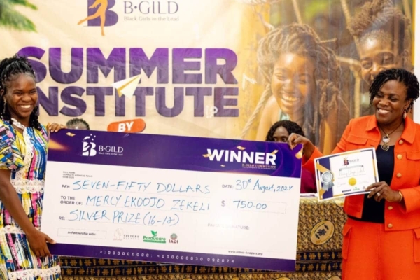 Mercy Ekoojo Zekeli wins the Silver Prize at B-GILD, proudly holding her $750 cheque for leadership and creativity.