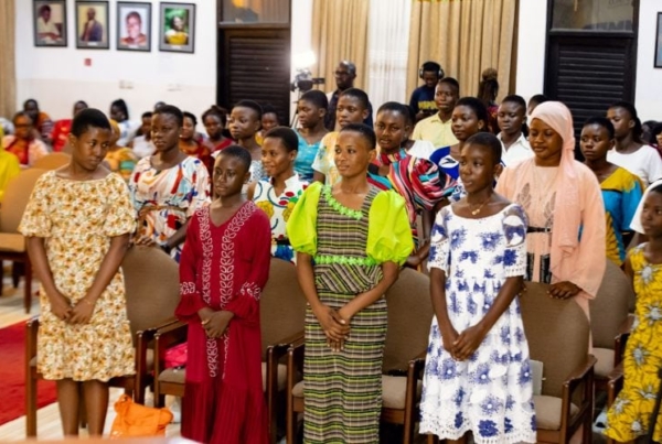 A group of young ladies attentively listening in a seminar.